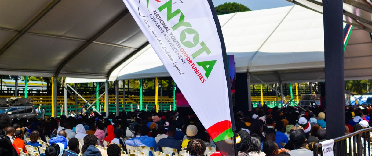 Young people gathered under a tent at a NYOTA Project event.